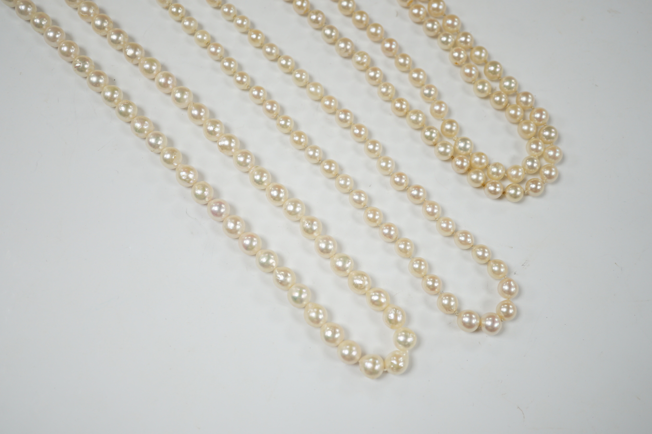 Three assorted modern single strand cultured pearl necklaces, one with 585 clasp, longest 76cm.